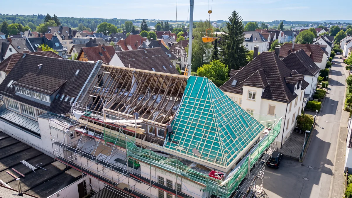 Dachsanierung an einem Altbau mit Gerüst und offenem Dachstuhl